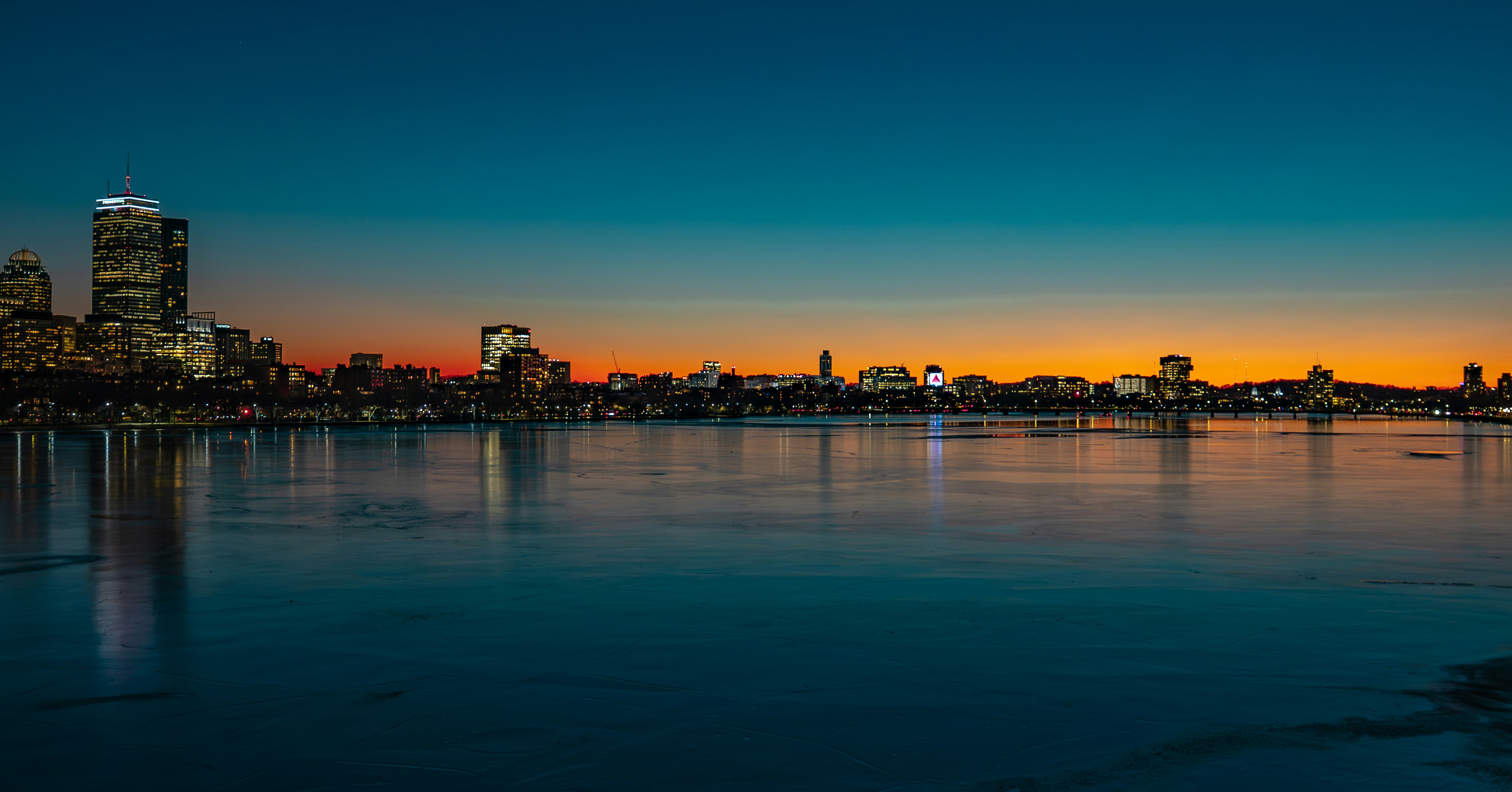 Boston skyline at sunset — departure city for flights to London